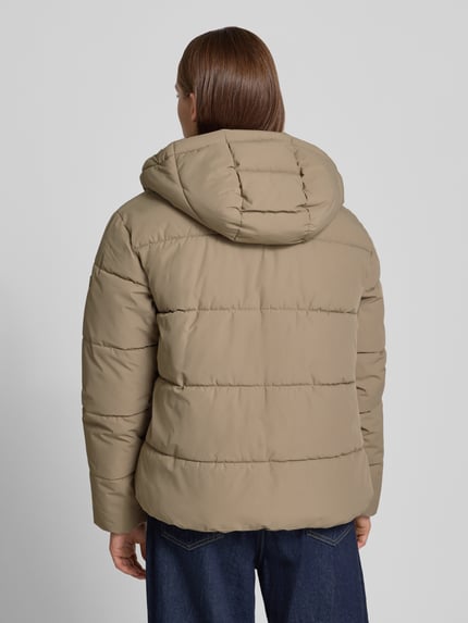 Vrouwenmodel draagt Regular Fit Jacke in Stiksels van Superdry in beige met Capuchon, opstaande kraag, Afdekstrip, tussenjack, Ganzkörperansicht Rückansicht. Ruglengte bij maat S: 64 cm, schouderbreedte: 49 cm, borstwijdte: 59 cm, mouwlengte: 62 cm.