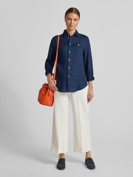 Vrouwenmodel draagt donkerblauwe Hemdbluse aus reinem Leinen van Polo Ralph Lauren, los vallend, met knoopsluiting, voorkant volledig zichtbaar.