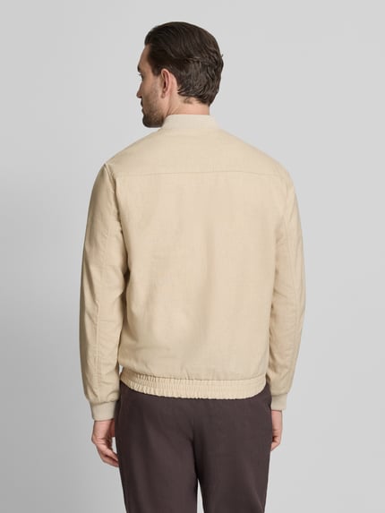 Männermodel trägt Jacke aus Baumwoll-Leinen-Mix mit Zweiwege-Reißverschluss von Jack & Jones Premium, Regular-Fit, Stehkragen, Rückenlänge 68 cm, Schulterbreite 45 cm, Brustweite 54 cm, Ärmellänge 66 cm, helle Beige-Töne mit feiner Textur, Ganzkörperansicht Rückansicht.