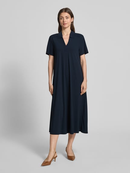 Frauenmodel trägt Midikleid mit Strukturmuster und Umlegekragen Modell 'JOSEPHINA' von Raffaello Rossi, dunkelblau, Ganzkörperansicht von vorne. Material-Mix mit Stretch-Anteil, lockerer Schnitt, V-Ausschnitt, kurze Ärmel.