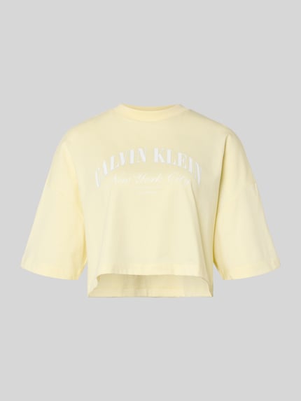 Produktfoto, Cropped T-shirt met logoprint van Calvin Klein Jeans van puur katoen, korte fit, ronde hals, ruglengte maat S 42 cm, lichtgeel