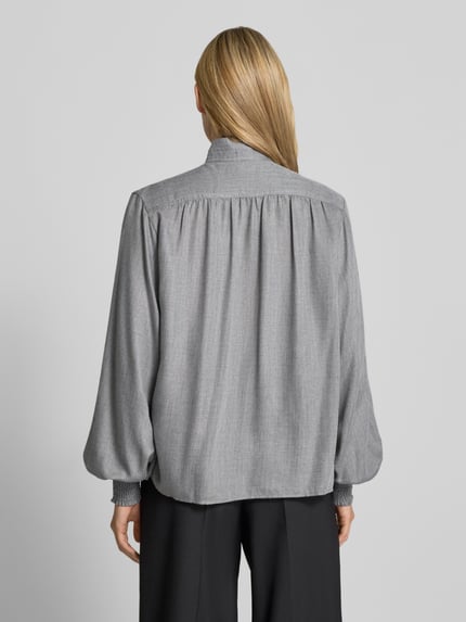 Vrouwenmodel draagt Relaxed Fit Hemdbluse aus Viskose-Mix Modell 'DUNIA' van 0039 Italy, grijs, smok-detail, langemouw, rugaanzicht, context: dames blouse, viscosemix, relaxed fit, opstaande kraag, ruglengte maat S 64 cm, mouwlengte maat S 67 cm.