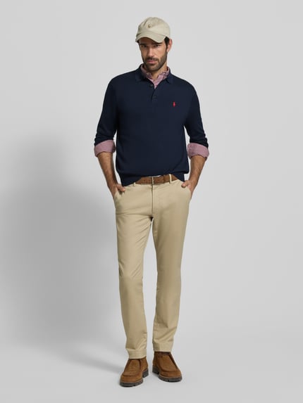 Männermodel trägt Regular Fit Poloshirt aus reiner Baumwolle von Polo Ralph Lauren in Optik: Unifarben, Strickoptik, Langarm, Feinstrick, Logo-Detail, Polokragen, Knopfleiste, Ärmelabschluss und Rumpfabschluss: gerippt, Material: Reine Baumwolle, Ganzkörperansicht von vorne.