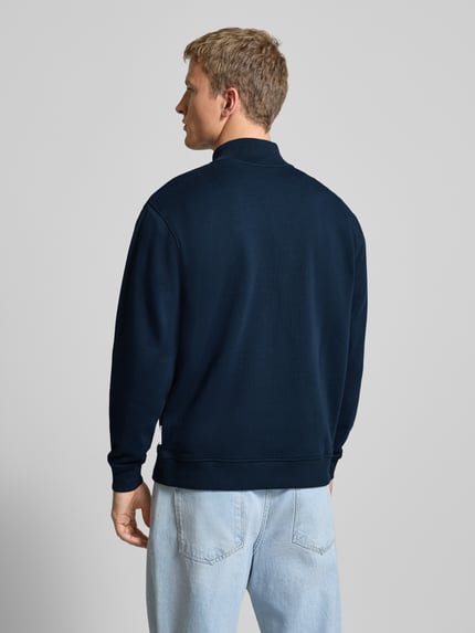 Männermodel trägt Regular Fit Troyer aus reiner Baumwolle von Marc O'Polo Denim in Dunkelblau, glatte Sweat-Textur, Ganzkörperansicht Rückansicht.