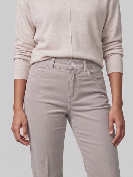 Frauenmodel trägt Regular Fit Cordhose mit Label-Patch Modell 'Lara' von ANGELS in Beige, Cordstruktur, 5-Pocket-Design, Nahaufnahme Oberkörper.