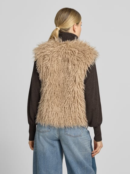 Frauenmodel trägt Weste mit V-Ausschnitt und verdecktem Verschluss von Smith and Soul aus beigem Faux Fur, gerade Form, Ganzkörperansicht Rückansicht.