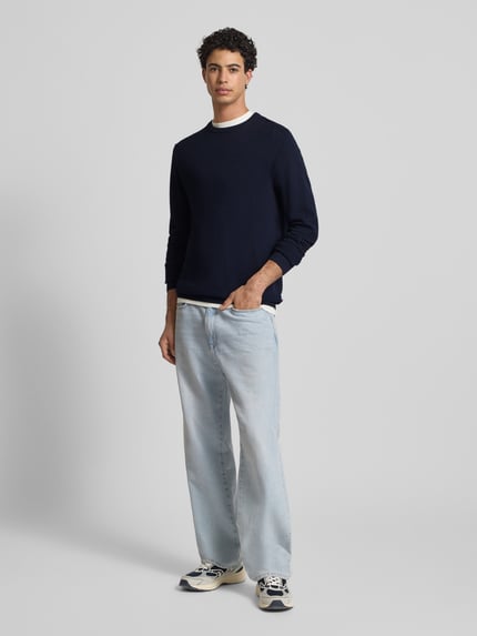 Männermodel trägt Strickpullover mit Rundhalsausschnitt Modell 'OTTO' von JACK & JONES in Dunkelblau, Strukturmuster, Regular-Fit, Reine Baumwolle, Ganzkörperansicht von vorne.