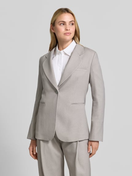 Frauenmodel trägt Blazer mit Reverskragen und Brustleistentasche von Emporio Armani in Hellgrau, Material-Mix mit Viskose-Anteil, taillierter Schnitt, Knopfverschluss, angedeutete Leistentaschen, Ganzkörperansicht von vorne.
