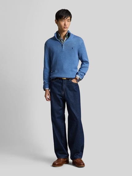 Mannenmodel draagt Regular fit schipperstrui uit puur katoen van Polo Ralph Lauren in lichtblauw, donkerblauwe broek, Ganzkörperansicht von vorne.