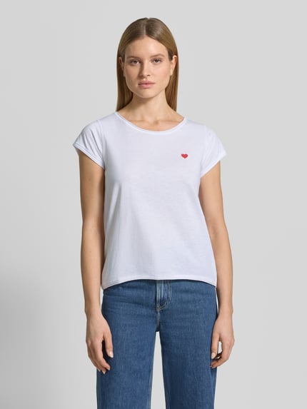 Kobiece modelka nosi T-Shirt mit Stitching und Rundhalsausschnitt od Christian Berg Woman, czysta bawełna, krój regular fit, biały kolor, rolkowane brzegi, długość tyłu w rozmiarze S: 62 cm, widok całej sylwetki z przodu.
