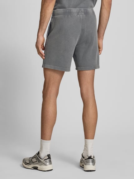 Männermodel trägt Shorts mit Strukturmuster und elastischem Bund von CHAMPION, Grau, Baumwoll-Mix, Regular Fit, Ganzkörperansicht Rückansicht.