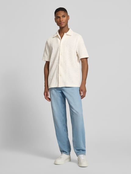 Mannenmodel draagt Regular Fit Freizeithemd met Kentkraag Modell 'Hector' van Les Deux, katoenmix, pointel breisel, knoopsluiting, licht beige tinten, gecombineerd met lichtblauwe jeans, geheel lichaamsaanzicht van voren.