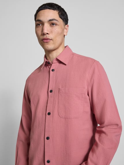 Männermodel trägt Regular Fit Freizeithemd aus reiner Baumwolle von Marc O'Polo Denim in Altrosa, Strukturmuster, Nahaufnahme Oberkörper.