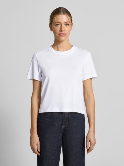 Kobiece model nosi Boxy Fit T-Shirt aus reiner Baumwolle von s.Oliver RED LABEL, efekt: jednolity kolor, krój: pudełkowy krój, okrągły dekolt, krótki rękaw, materiał: bawełna; Ganzkörperansicht von vorne.