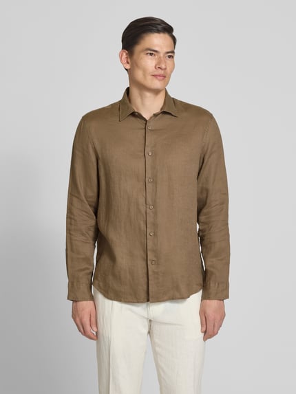 Männermodel trägt Regular Fit Freizeithemd aus reinem Leinen Modell 'KYLIAN' von SELECTED HOMME in Unifarben, Flammgarn-Struktur, Ganzkörperansicht von vorne.