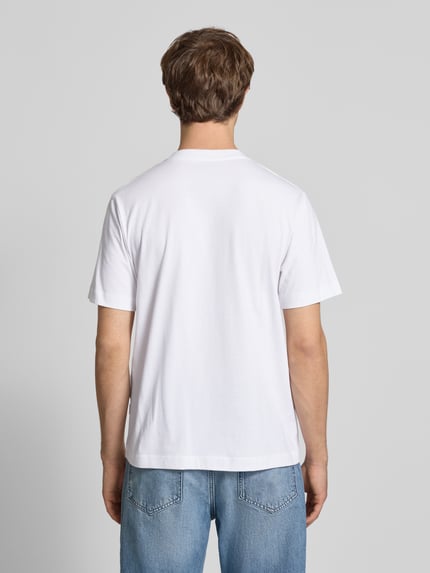Männermodel trägt T-Shirt mit Label-Stitching Modell 'NORREBRO' von Jack & Jones in Weiß, reine Baumwolle, Regular Fit, Ganzkörperansicht Rückansicht.