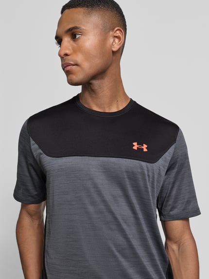 Mannelijk model draagt Regular Fit T-shirt met logo-print model 'Utility' van Under Armour in elastische mix, grijze en zwarte tinten, Nahaufnahme bovenlichaam.
