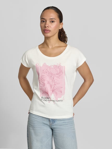 Frauenmodel trägt Regular Fit T-Shirt aus Viskose-Mix mit floralem Print von Christian Berg Woman in Weiß und Rosa, Nahaufnahme Oberkörper.