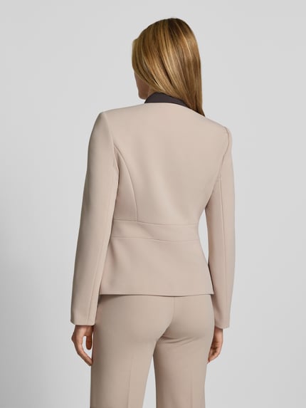 Frauenmodel trägt Kurzblazer mit Label-Detail von Rinascimento in Beige, taillierte Passform, glatte Struktur, Ganzkörperansicht Rückansicht