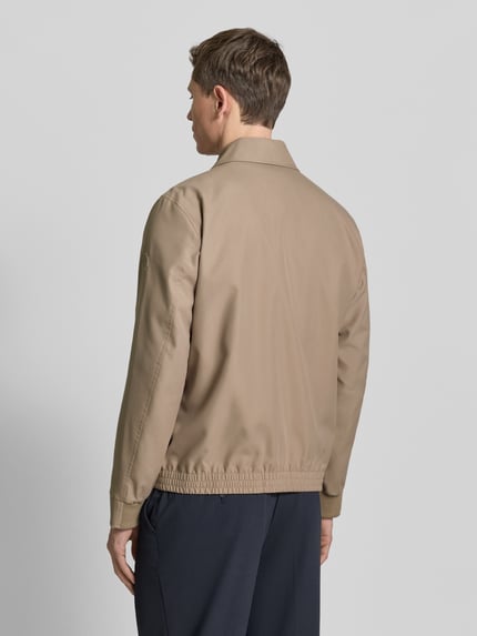 Männermodel trägt Regular Fit Blouson mit Umlegekragen Modell 'LIGHT 2.0' van Strellson in effen lichtbruin, elastische zoom, lange mouw, achteraanzicht fullbody.