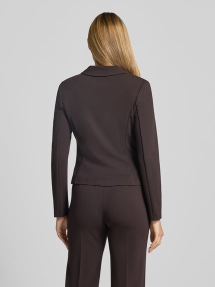 Vrouwenmodel draagt Slim Fit Blazer mit Reverskraag van Rinascimento in donkerbruine elastische materiaalmix met klepzakken, ruglengte maat S 53 cm, geheellichaamsaanzicht achterkant