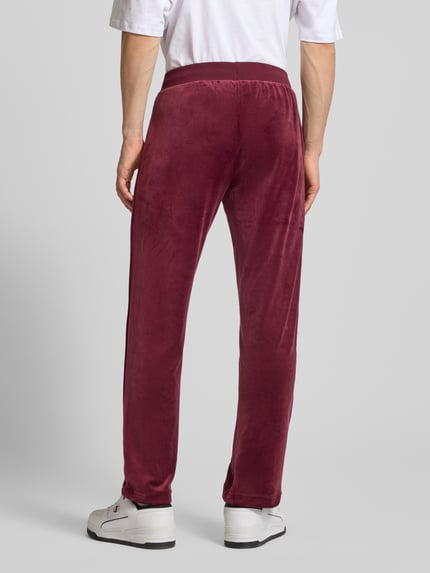Männermodel trägt Sweatpants mit elastischem Bund von SERGIO TACCHINI, Material-Mix mit Stretch-Anteil, lockerer Schnitt, Ganzkörperansicht Rückansicht.