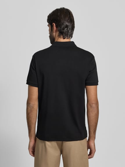 Männermodel trägt Poloshirt mit Label-Stitching von Polo Ralph Lauren in Schwarz, Reine Baumwolle, Regular-Fit, Rückenlänge 69 cm, Ganzkörperansicht Rückansicht.