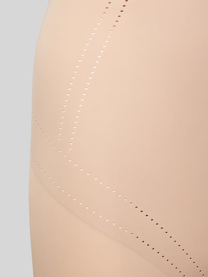 Frauenmodel trägt High Waist Pants mit Lochmuster Modell 'Dream' von MAGIC Bodyfashion aus Material-Mix mit Stretch-Anteil, Nahaufnahme Oberkörper.