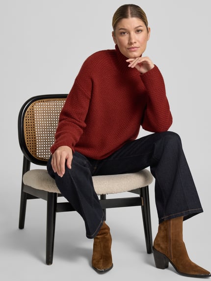 Vrouwenmodel draagt Strickpullover aus Kaschmir mit Stehkragen van windsor., rood, structuurpatroon, relaxed fit, pure kasjmier, met hoge kraag, gecombineerd met donkere jeans en bruine laarzen, totaalbeeld van voren.