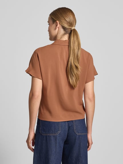 Vrouwenmodel draagt Regular Fit blouse uit viscose met knoopdetail model 'RADIA' van Soyaconcept, dames, reverskraag, knoopsluiting, ruglengte maat S 55 cm, mouwlengte maat S 10 cm, egale bruine kleur, zachte stofstructuur, lichte glans, geheel glad, model van achteren, geheel lichaamsaanzicht rugaanzicht.