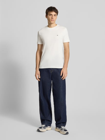Mannelijk model draagt Slim Fit T-Shirt aus reiner Baumwolle im 2er-Pack van Tommy Jeans, wit, unifarben, kort mouw, logo-detail, Ganzkörperansicht von vorne.