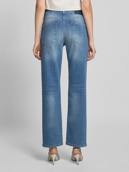 Frauenmodel trägt Straight Fit Jeans aus Baumwoll-Mix Modell 'GINI' von CAMBIO in mittelblau mit sichtbaren Nähten, Ganzkörperansicht Rückansicht, Damen Straight Fit Jeans von CAMBIO.