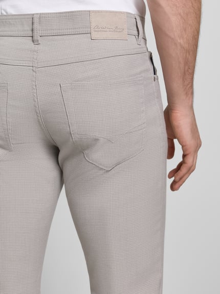 Mannenmodel draagt Chino met 5-Pocket-Design van Christian Berg Men, rechte fit, viscosemix in lichtgrijs, detailopname achterzijde.