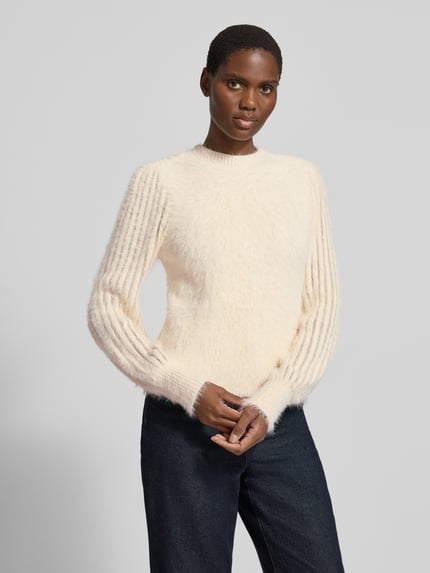 Kobiece model prezentuje Regular Fit Strickpullover aus Baumwoll-Mix mit Viskose-Anteil od zero, mieszanka bawełny i wiskozy, krój regular fit, stójka, prążkowane wykończenia, długość tyłu w rozmiarze 36: 52 cm, długość rękawów w rozmiarze 36: 69 cm, kremowy sweter z dzianiny o miękkiej fakturze, pełny widok od przodu