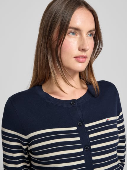 Frauenmodel trägt Regular Fit Strickjacke aus Baumwoll-Mix von Tommy Hilfiger, Optik:Allover-Muster, gestreift, Logo-Stitching, Rundhals, Langarm, Feinstrick, Nahaufnahme Oberkörper.