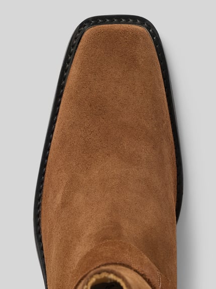 Produktfoto, Biker Boots aus echtem Leder von Anine Bing in braun, eckige Form, Nietenbesatz, feine Struktur sichtbar, Detailaufnahme.