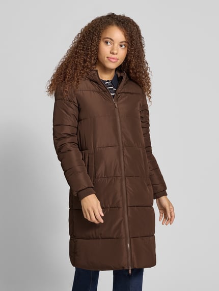 Frauenmodel trägt braunen Puffer Coat mit Kapuze von PIECES, unifarben, Longline, seitliche Eingrifftaschen, Reißverschluss, Ganzkörperansicht von vorne