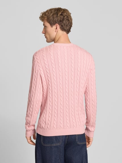 Männermodel trägt Slim Fit Strickpullover reine Baumwolle von REVIEW in Rosa mit Zopfmuster, gerippten Bündchen, Ganzkörperansicht Rückansicht.