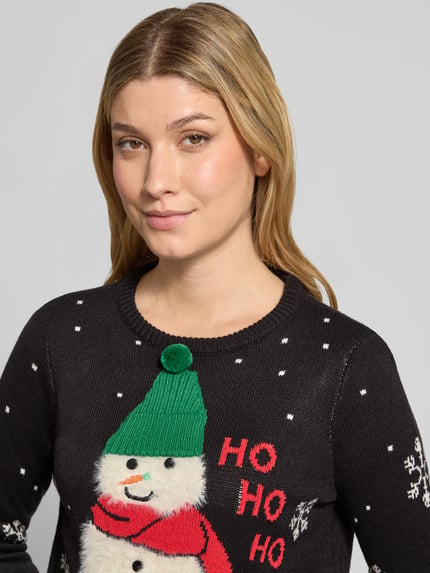 Frauenmodel trägt Pullover mit flauschigem Schneemann-Motiv von VERO MODA, mehrfarbig, Strickoptik, Nahaufnahme Oberkörper.