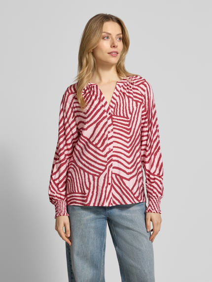 Modelka nosi Hemdbluse mit Knopfleiste Modell 'BECCA' od Soyaconcept, wzór w czerwone i białe paski, luźny krój, V-dekolt, mieszanka wiskozy, widok całej sylwetki z przodu.