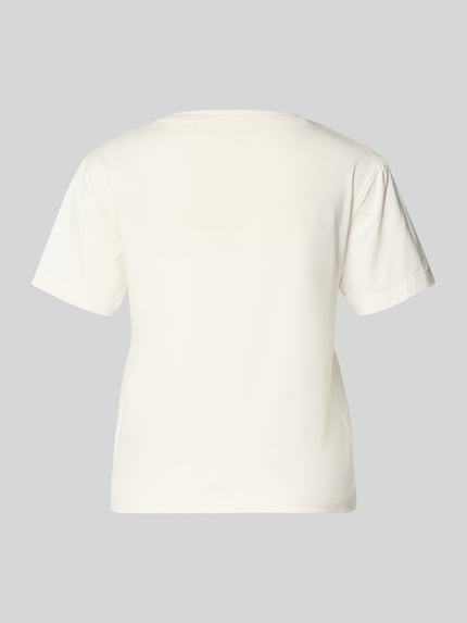 Vrouwenmodel draagt Regular Fit Pyjama-Oberteil aus Modal-Mix mit Baumwoll-Anteil Modell 'NIKKA' van HUGO, effen crème kleur, korte mouw, ronde hals, jersey structuur, labeltekst applicatie, Ganzkörperansicht Rückansicht.