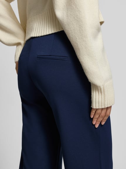 Kobiece modelka nosi granatowe Wide Fit Stoffhose mit Viskose-Anteil Modell 'Nanni' od FREE/QUENT, elastyczny materiał, kieszenie z tyłu, szerokość w rozmiarze S: 40 cm, długość nogawki wewnętrznej: 79 cm, widok z tyłu zbliżenie na biodra.