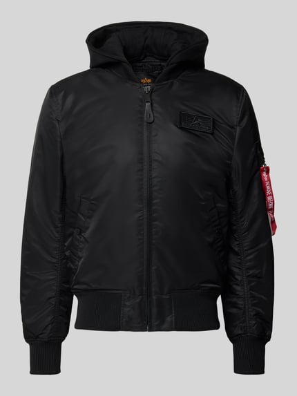 Produktfoto, schwarze Regular Fit Bomberjacke mit Kapuze von Alpha Industries, Zipper, Label-Patch, Armtasche, Webstoff, gerippte Abschlüsse.