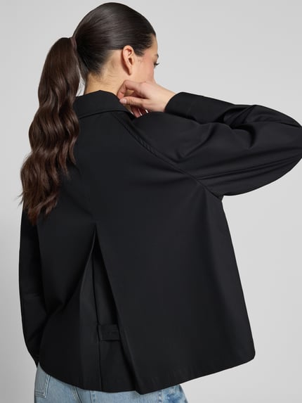 Frauenmodel trägt Relaxed Fit Trenchcoat aus reiner Baumwolle von Tommy Hilfiger in Optik: Unifarben, wasserabweisend, Twill, Logo-Detail, Cropped, Ganzkörperansicht Rückansicht.