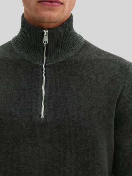 Männermodel trägt Pullover mit halblangem Reißverschluss von MARC O'POLO in Dunkelgrau, Strukturmuster, hochgeschlossener Troyerkragen, Nahaufnahme Oberkörper.
