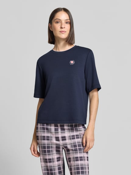 Vrouwenmodel draagt Relaxed Fit T-shirt uit viscosemix van Marc Cain in donkerblauw met logodetail, ronde hals, ruglengte maat 36: 54 cm, elastische viscosemix, voorkant volle lichaamsweergave.