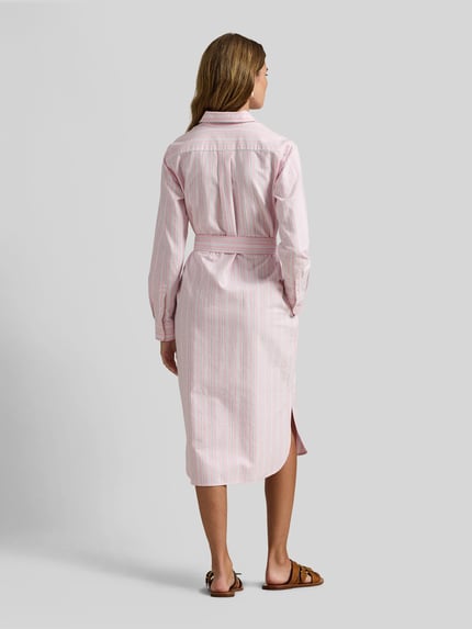 Vrouwenmodel draagt Regular Fit Oxford-Hemdblusenkleid mit Gürtel van Polo Ralph Lauren, roze-wit gestreept katoen, geheel achteraanzicht.