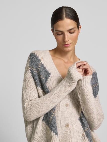 Vrouwenmodel draagt Strickjacke met V-hals van Luisa Cerano, materiaalmix met alpaca, relaxed fit, all-over look, knoopsluiting, beige en grijs, ruglengte maat 36: 61 cm, mouwlengte maat 36: 46 cm, detailopname bovenlichaam.