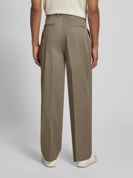 Männermodel trägt Hose mit Bügelfalten Modell 'Reece' von Les Deux in Beige, Regular Fit, Lyocell-Baumwoll-Mix, Ganzkörperansicht Rückansicht.