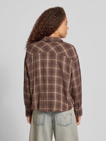 Frauenmodel trägt Regular Fit Hemdbluse aus reiner Baumwolle Modell 'FAJAN' von ONLY, braunes Karomuster, Damen Hemdbluse, Ganzkörperansicht Rückansicht.